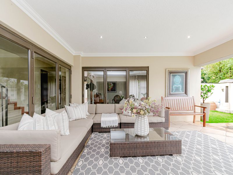A spacious covered patio featuring tiled flooring, recessed lighting, and large sliding glass doors providing seamless access to the interior living areas.