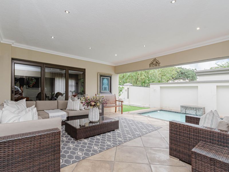 Covered patio area featuring tiled flooring, recessed lighting, and direct access to a private plunge pool and garden.