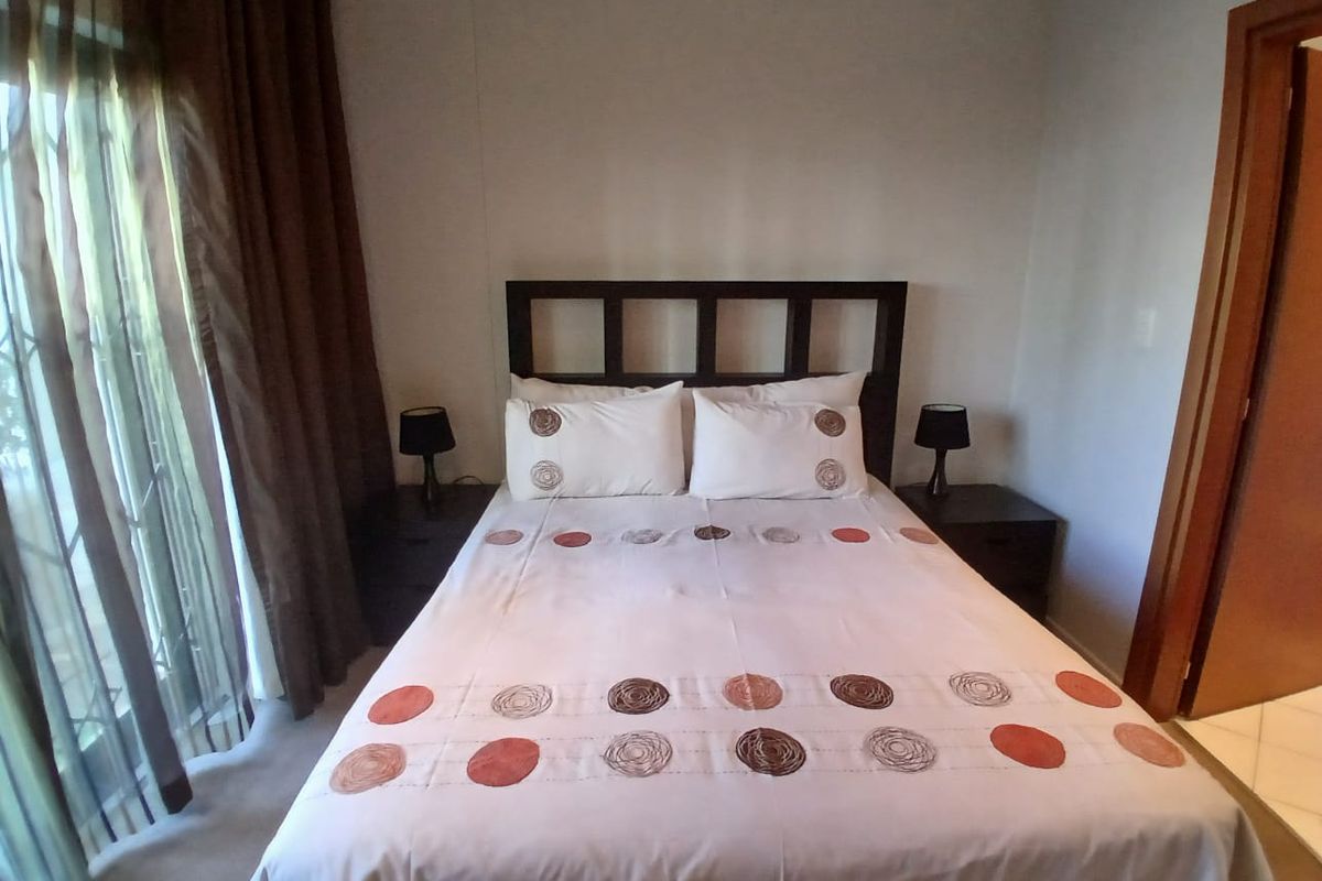 A bedroom featuring tiled flooring and a sliding glass door providing access to the exterior.