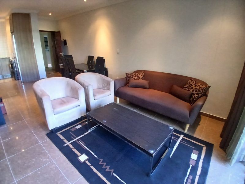 Open plan living and dining area featuring tiled flooring and recessed lighting, providing a functional space for relaxation and meals.