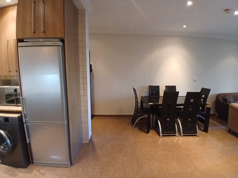 Open plan living and dining area featuring tiled flooring, recessed lighting, and integrated kitchen cabinetry.