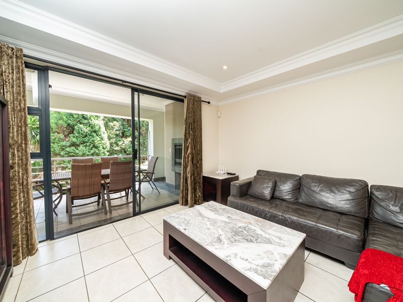 Spacious living area featuring large sliding glass doors that open onto a covered patio, providing seamless indoor-outdoor flow and natural light.