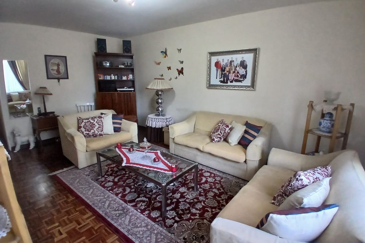 A living room featuring parquet flooring and a central ceiling light fixture, providing a comfortable and traditional living space.