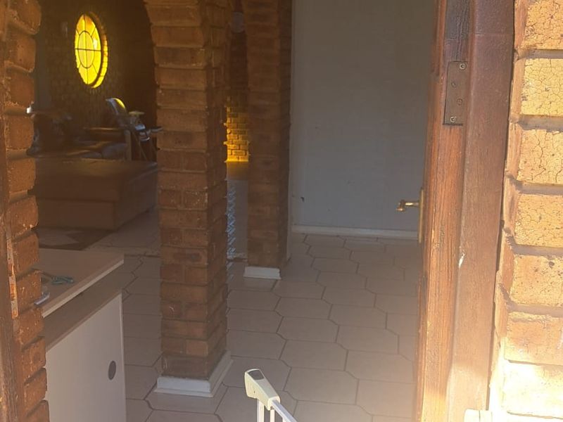 Entrance area featuring distinctive brick archways and tiled flooring, leading into an open living space with a decorative stained glass window.