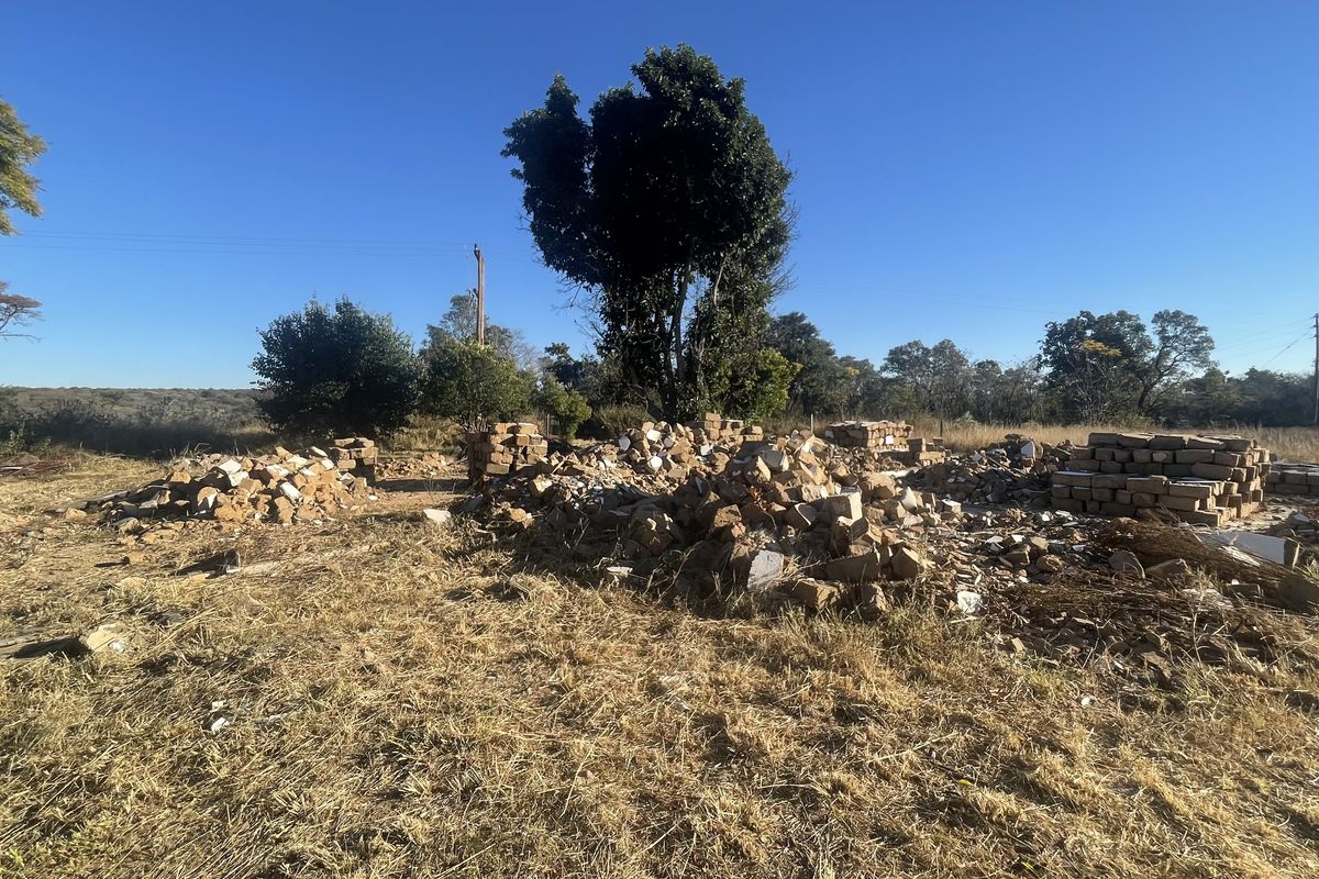 A vacant plot of land featuring piles of salvaged bricks and building materials, suitable for new development or construction projects.