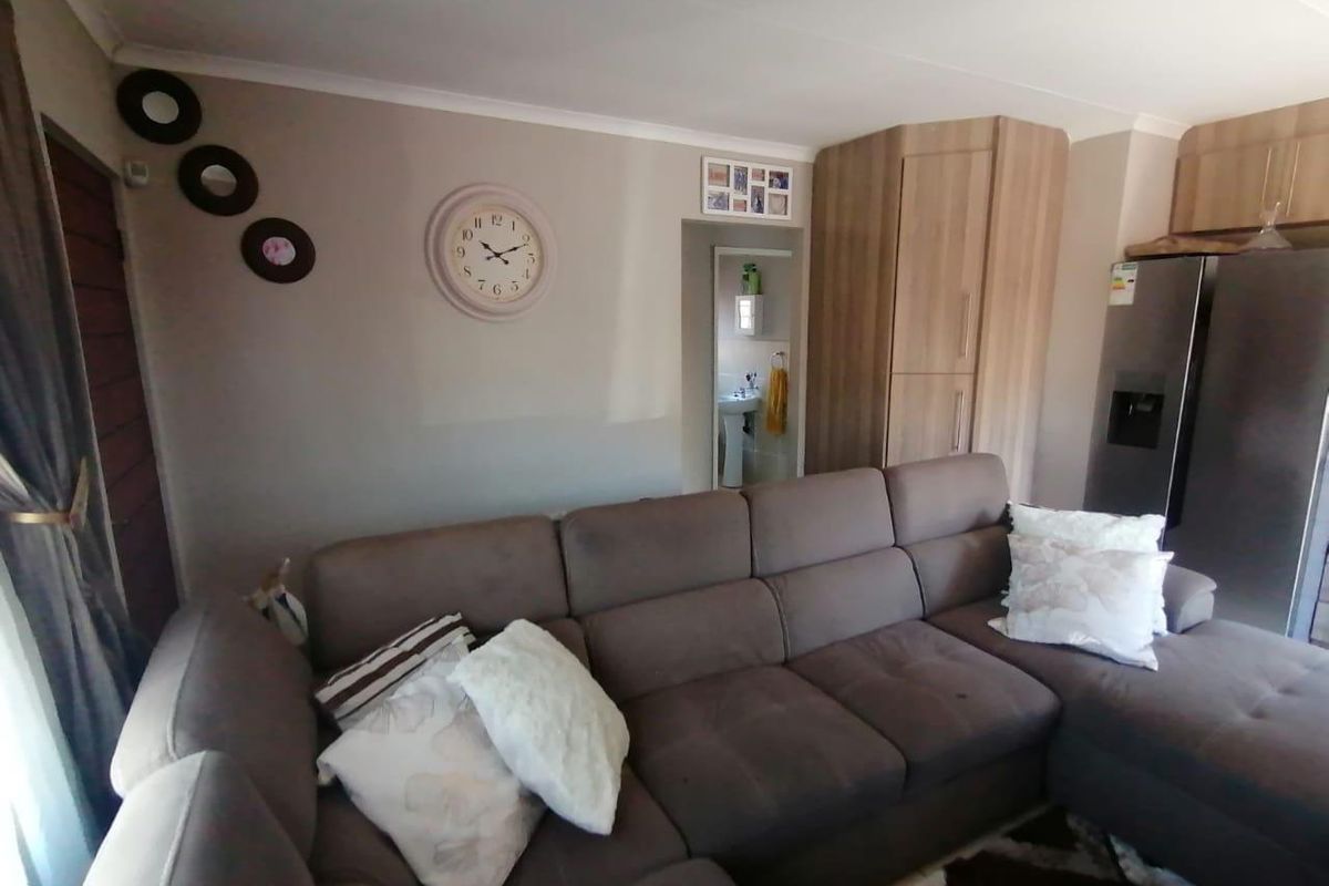 A view of the living area featuring built-in cabinetry and a doorway leading to an adjacent bathroom space.