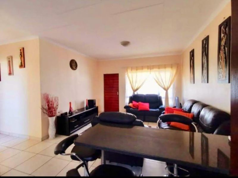 Open-plan living area featuring tiled flooring and neutral wall finishes, providing a versatile space for dining and relaxation.