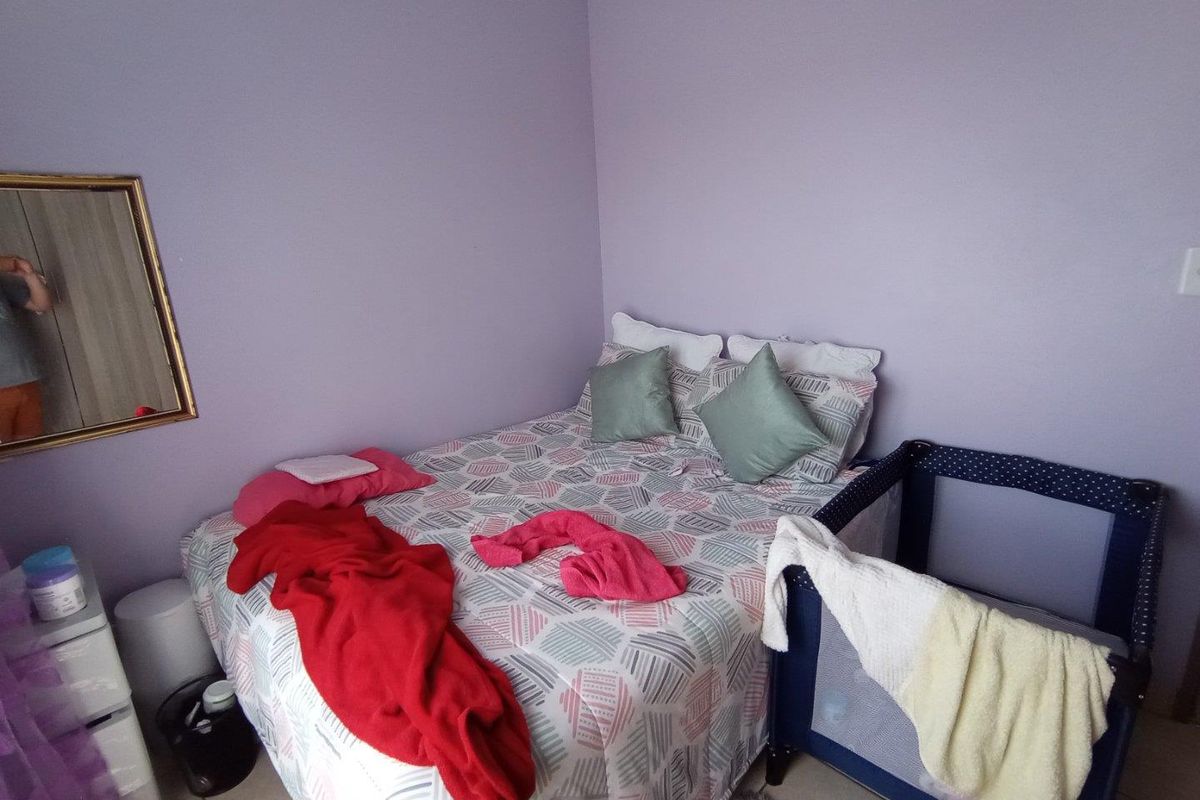 A standard bedroom featuring tiled flooring and purple painted walls, providing a functional space for rest.