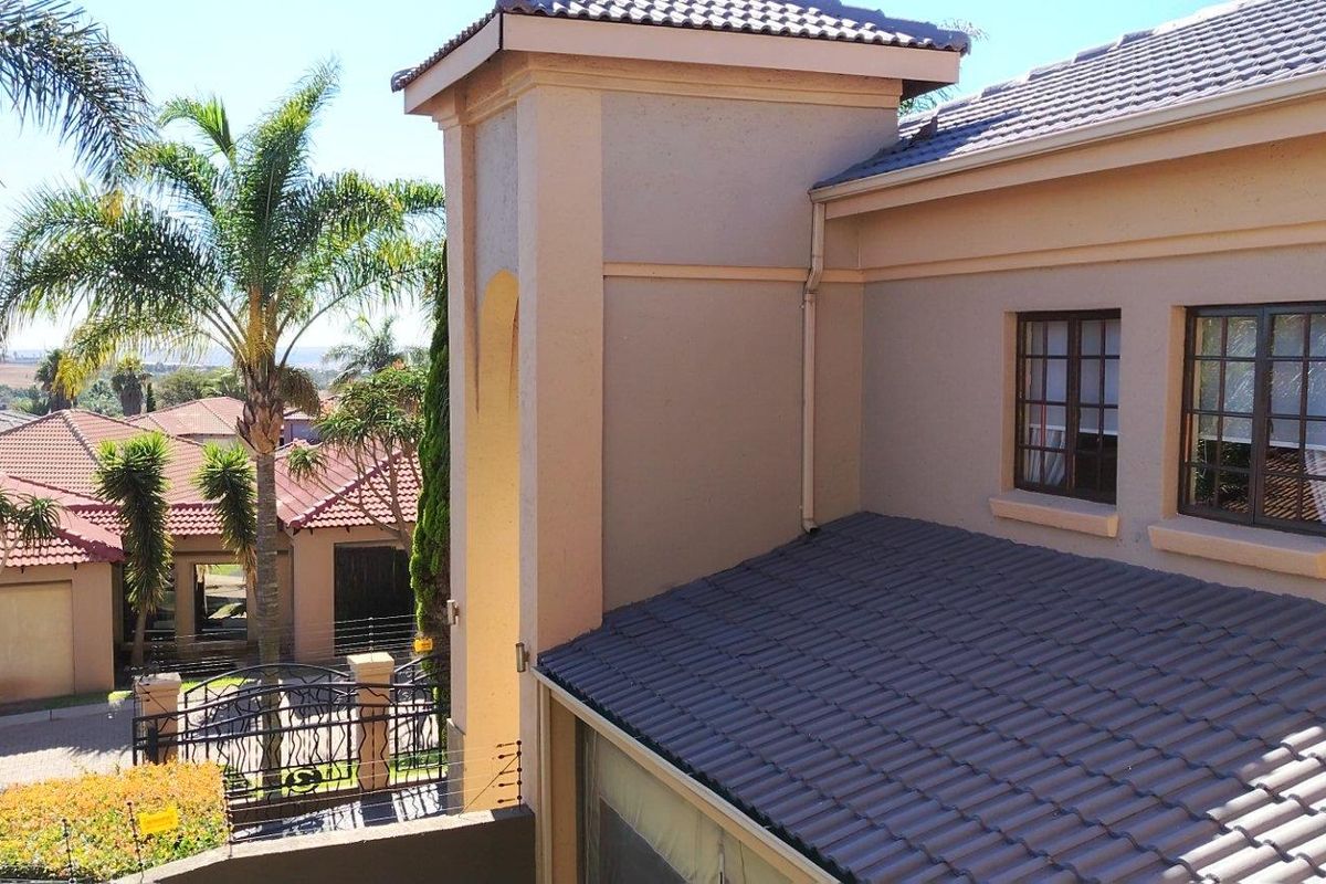 An elevated view of the property exterior, showcasing the tiled roof, architectural tower feature, and surrounding residential neighbourhood.