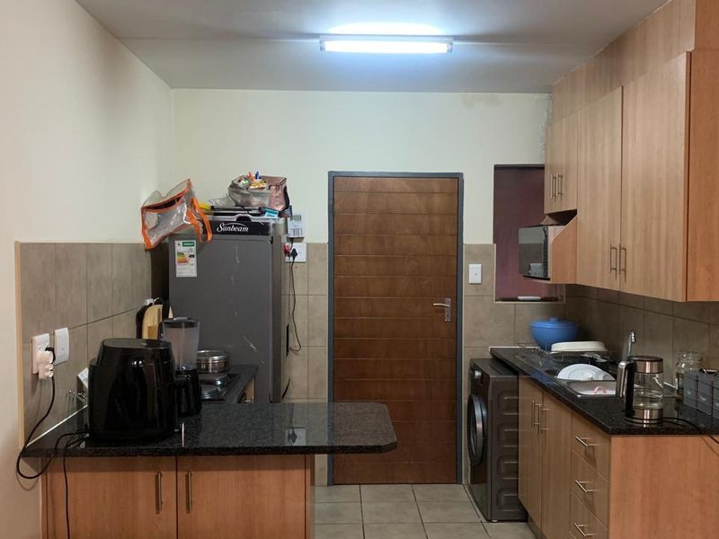 Functional kitchen featuring laminate cabinetry, granite countertops, tiled backsplash, and tiled flooring, providing a practical workspace for daily meal preparation.