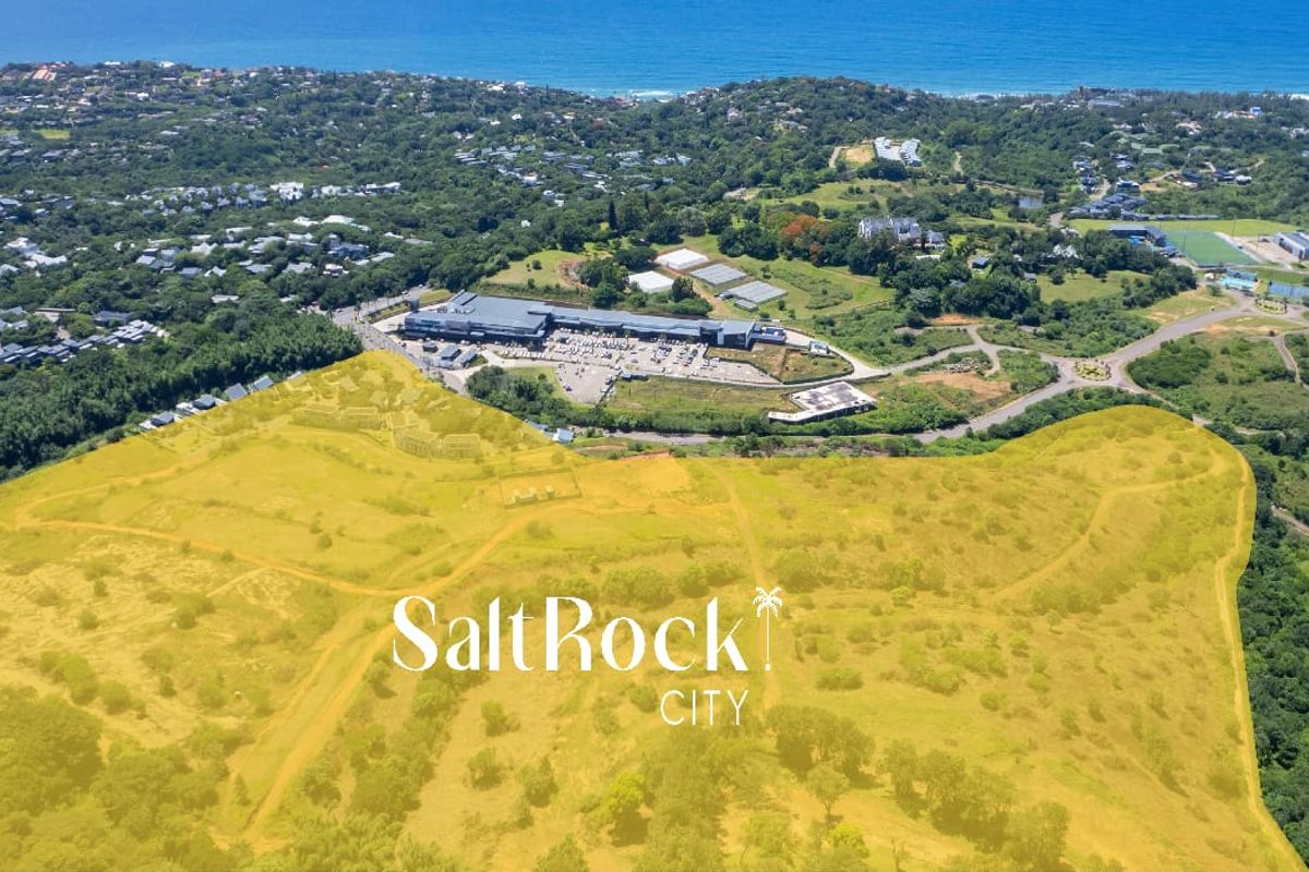 Aerial view of a large undeveloped land parcel in Salt Rock, showcasing the surrounding coastal landscape and nearby commercial infrastructure.