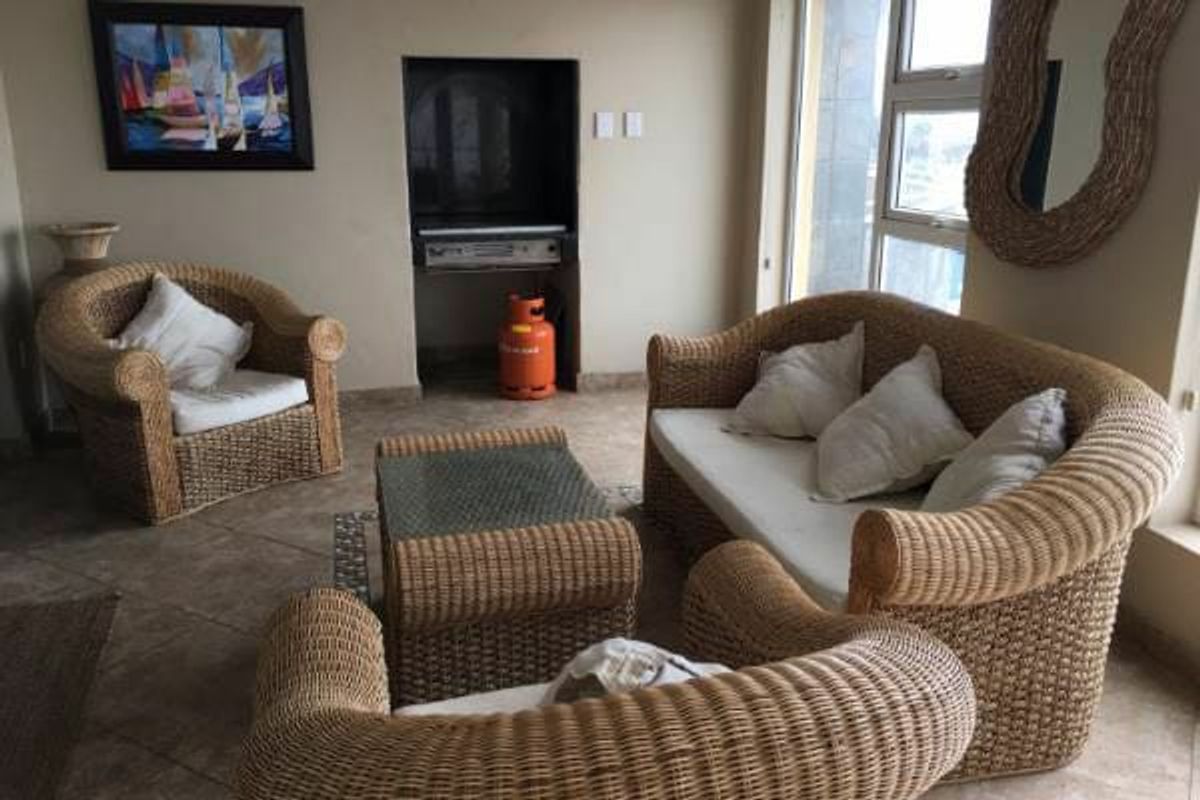 A living room area featuring tiled flooring and a built-in wall niche for media equipment.