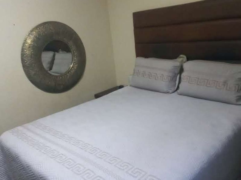 A standard bedroom featuring a built-in headboard and neutral wall finishes.