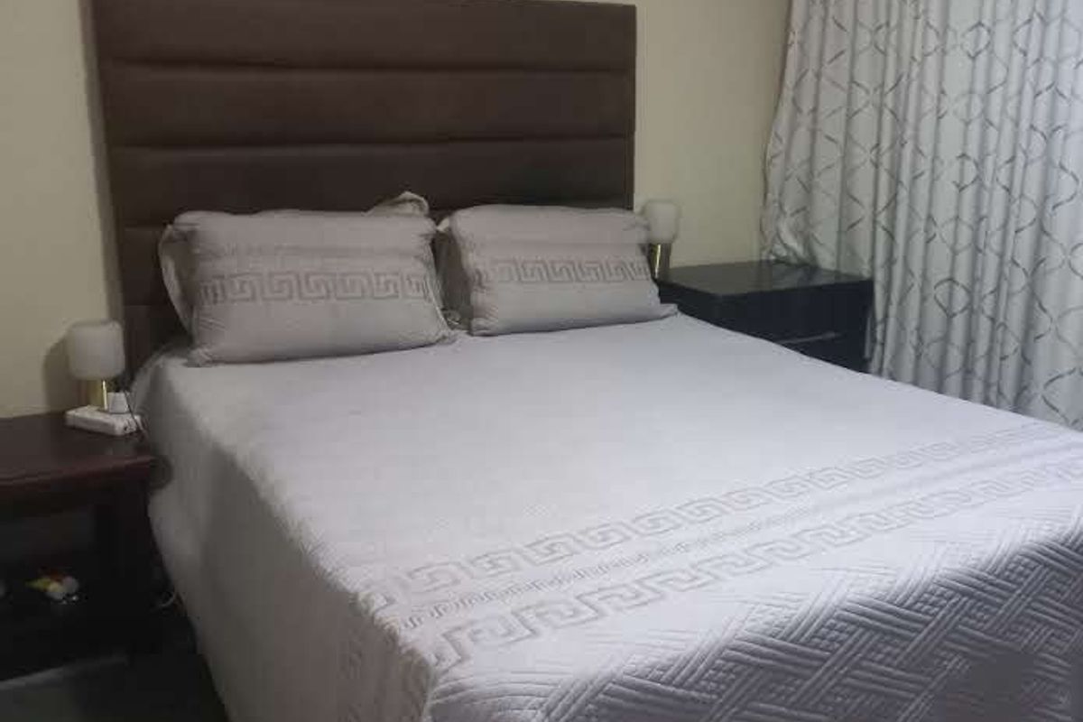 A standard bedroom featuring neutral wall finishes and window treatments.