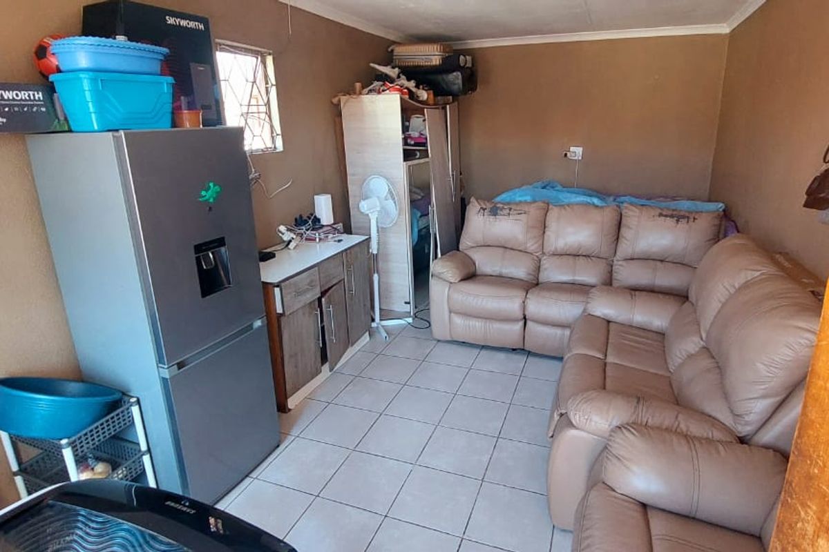 A compact living area featuring tiled flooring and basic wall finishes, suitable for a small lounge or multi-purpose room.
