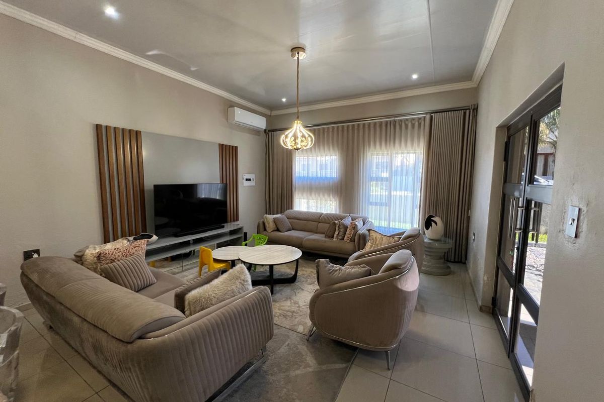 A well-maintained living room featuring tiled floors, a decorative feature wall, recessed lighting, and a split-system air conditioner.