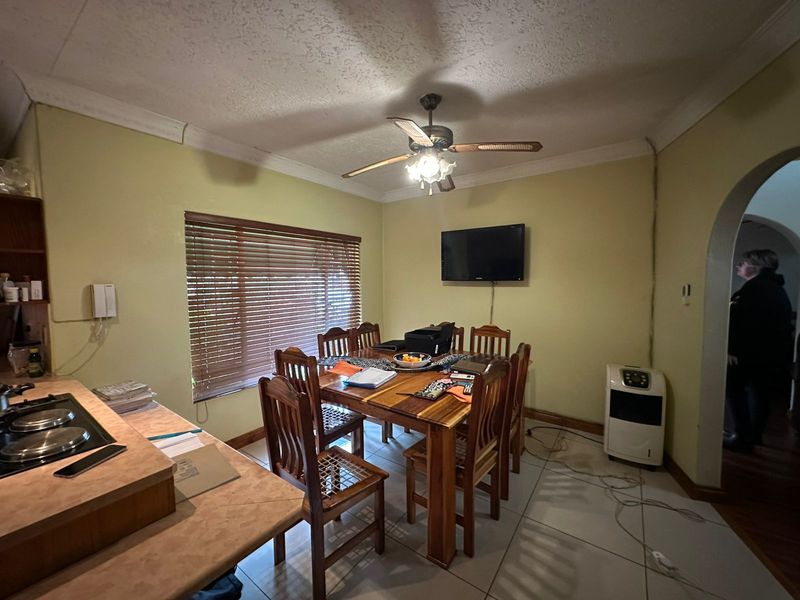 Open plan dining area featuring tiled flooring, ceiling fan, and integrated kitchen counter space with a built-in hob.