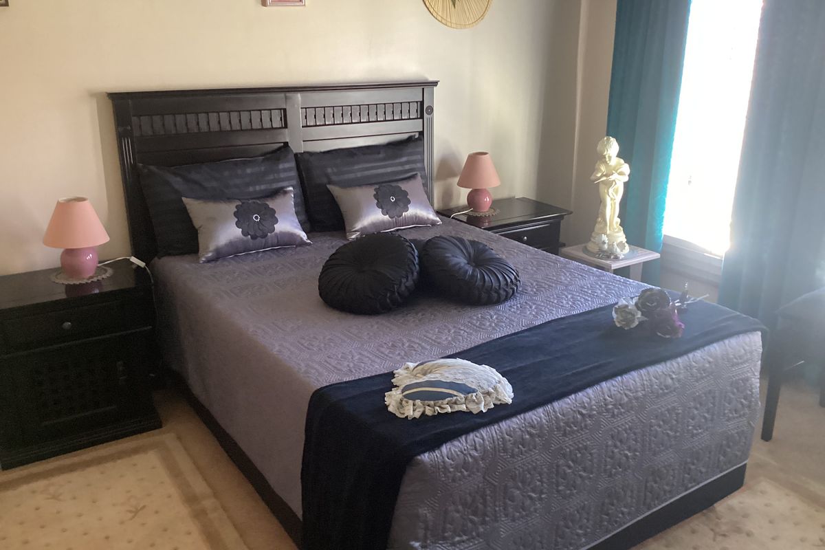 A well-lit bedroom featuring neutral wall finishes and carpeted flooring, providing a comfortable and functional sleeping space.