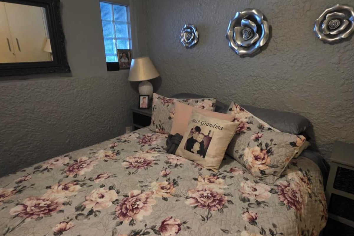 A cozy bedroom featuring a textured wall finish, a glass block window, and built-in wardrobe storage.
