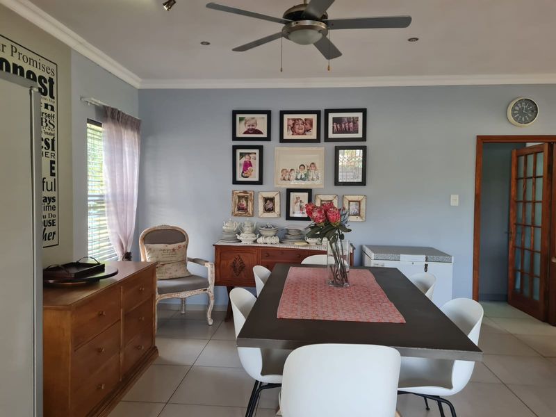 A dining room featuring tiled flooring, a ceiling fan, and a wooden door frame leading to an adjacent space.
