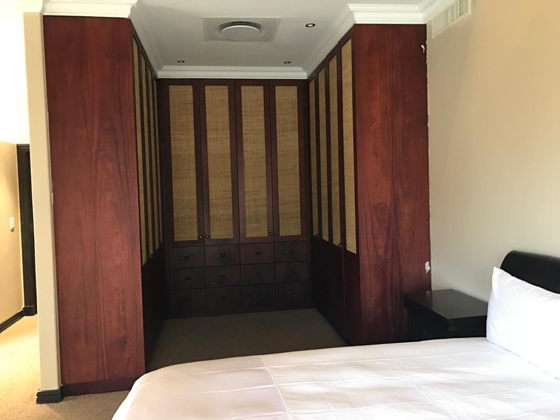 Bedroom featuring extensive built-in wooden cabinetry with integrated drawers and recessed ceiling lighting.