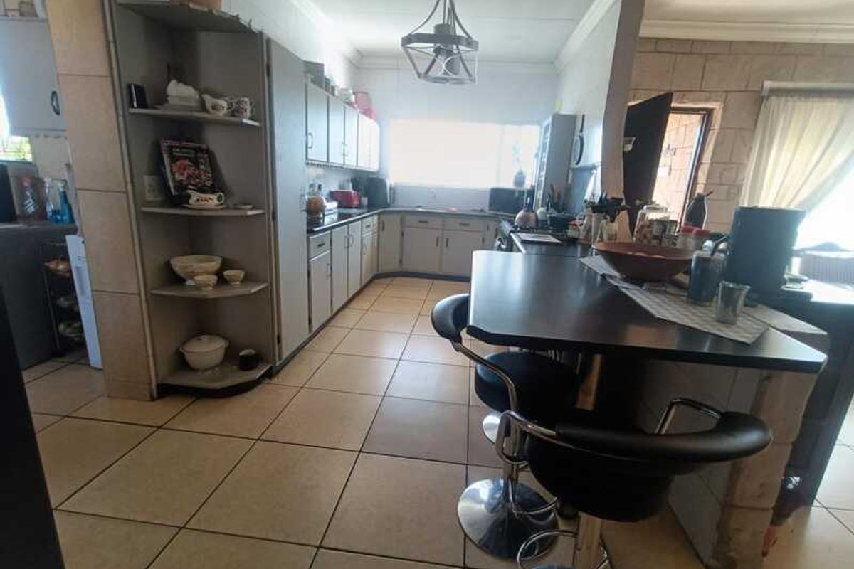 A functional kitchen featuring built-in cabinetry, a breakfast bar, and tiled flooring, offering a practical layout for daily meal preparation.