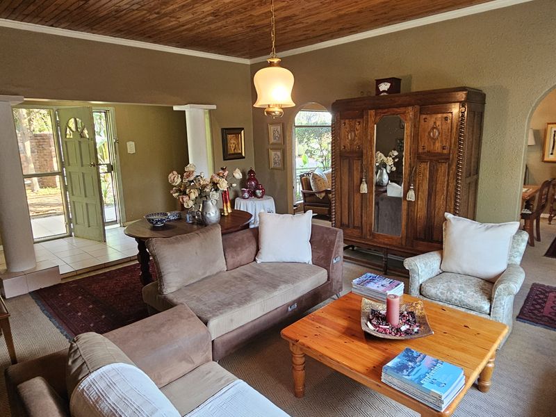 Spacious living room featuring a wood-paneled ceiling, arched entryways, and direct access to the front entrance area.