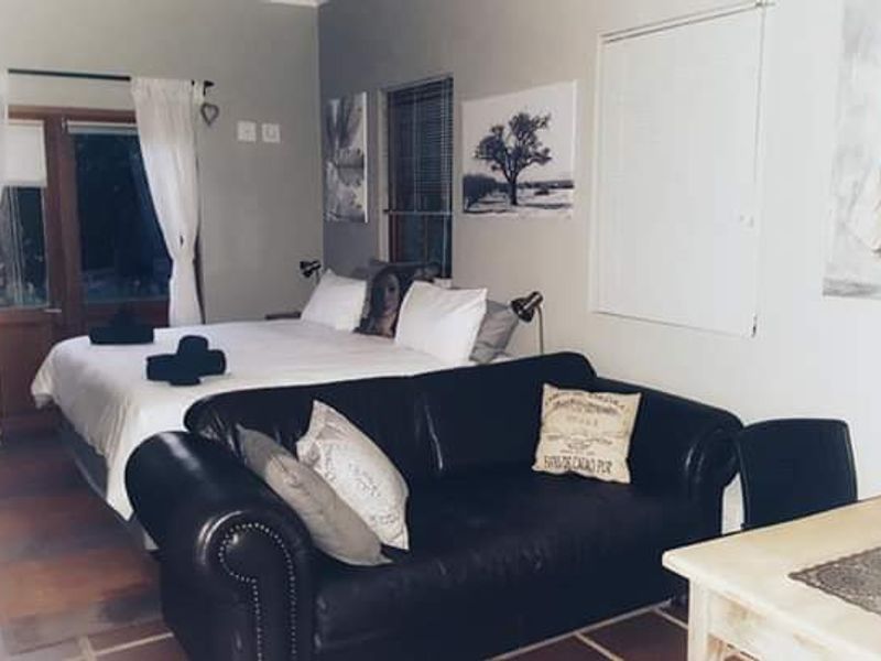 A bedroom featuring tiled flooring and french doors leading to the exterior, with neutral wall tones and window blinds.