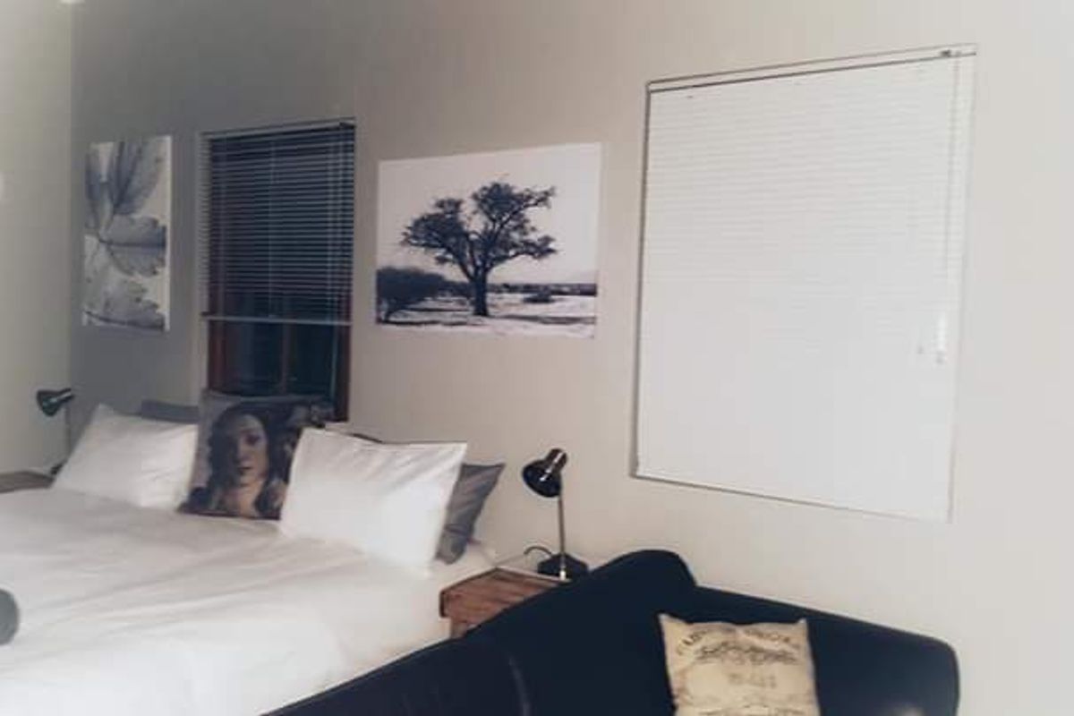 A bedroom featuring neutral walls and fitted venetian blinds, providing a functional and simple living space.