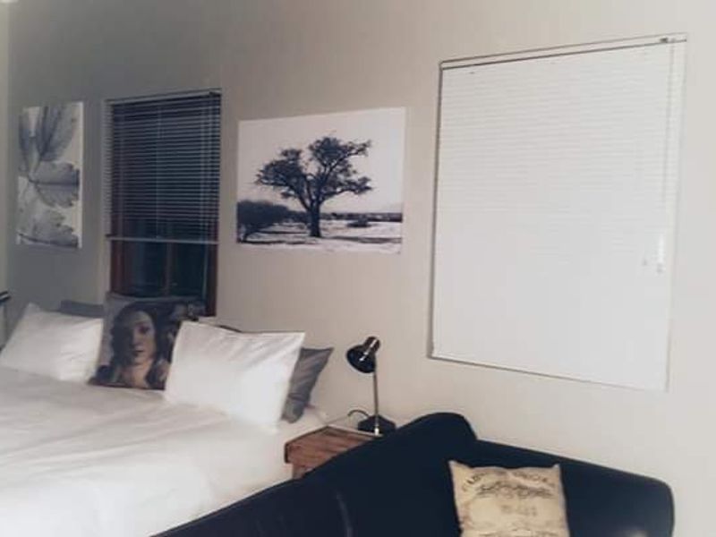 A bedroom featuring neutral walls and fitted venetian blinds, providing a functional and simple living space.