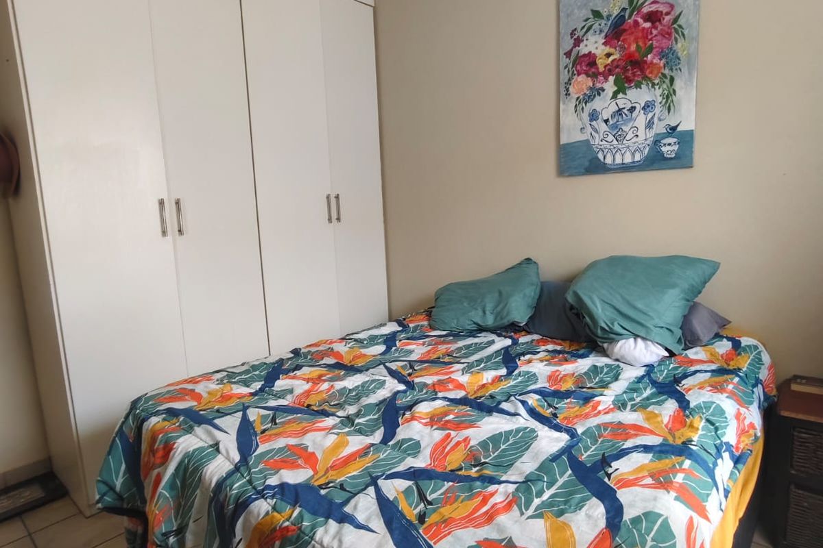 A bedroom featuring built-in cupboards and tiled flooring.
