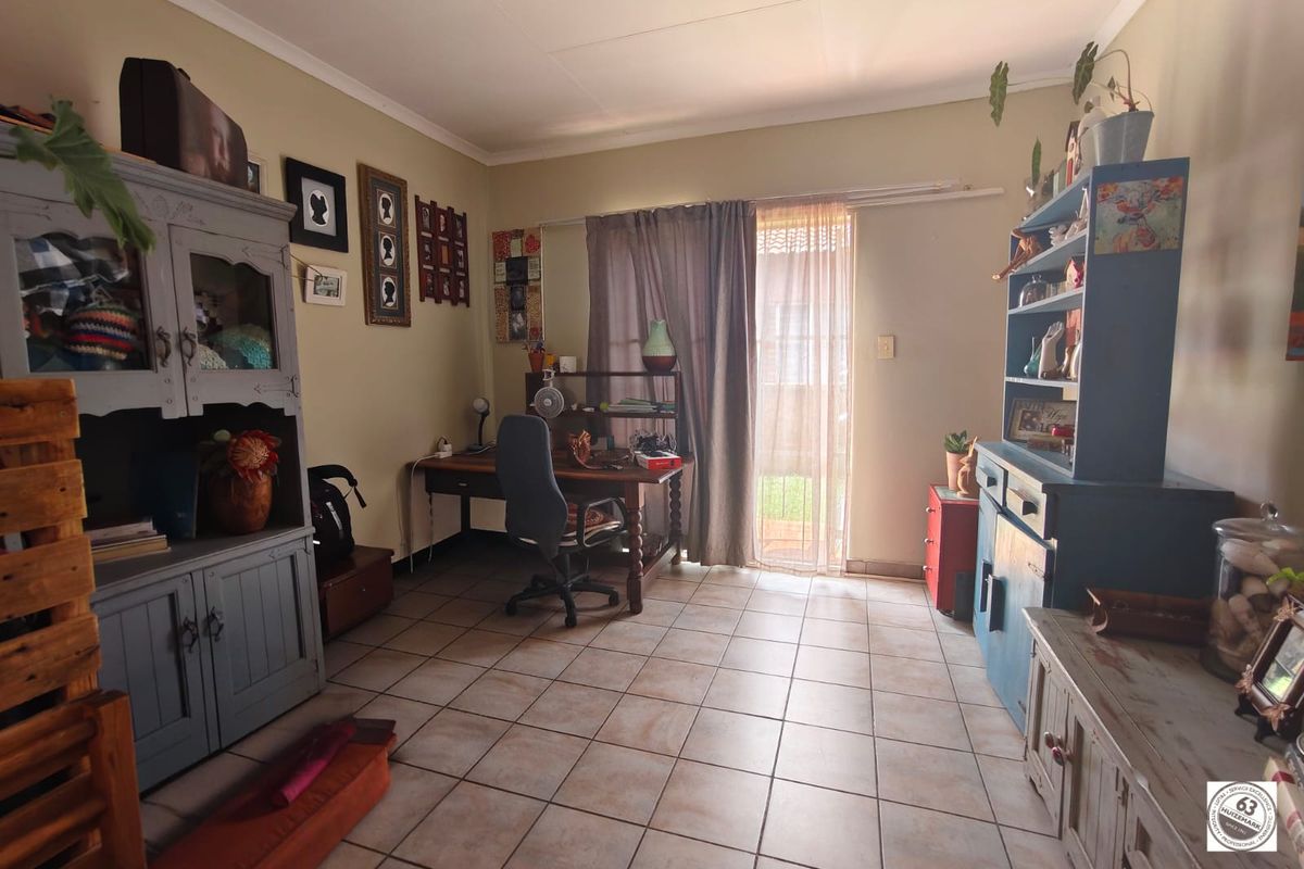 A functional living space featuring tiled flooring and a sliding glass door providing access to the exterior.