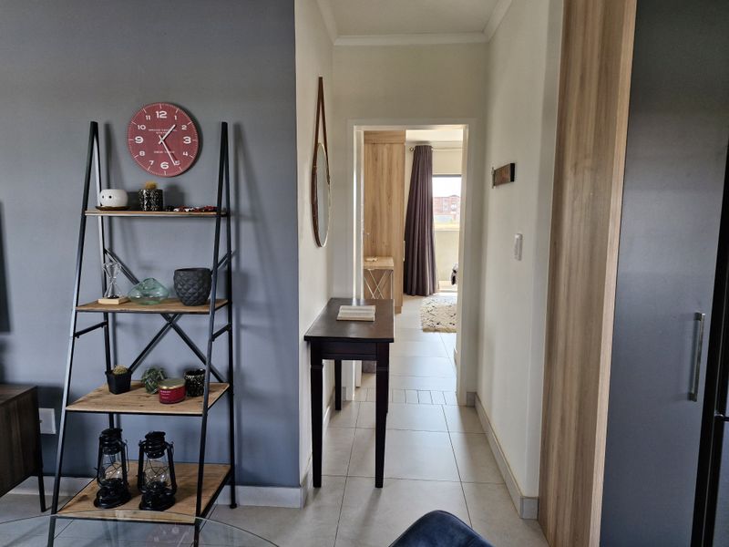 A well-maintained hallway featuring neutral tiled flooring and modern built-in cabinetry, providing a clean transition between living spaces.