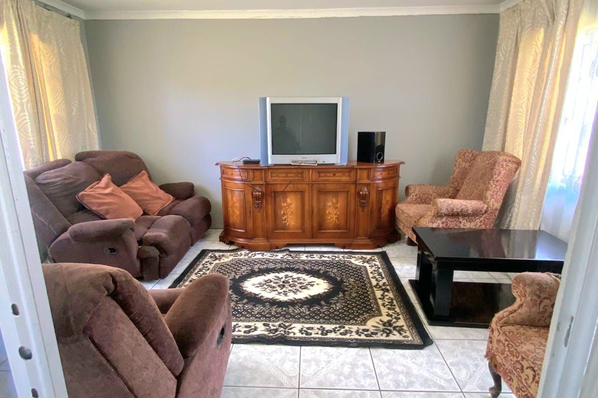 A living room featuring tiled flooring and neutral wall finishes, providing a functional space for relaxation.