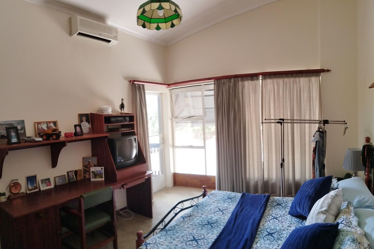 A bedroom featuring a split-system air conditioner, coved cornicing, and access to an outdoor area via a sliding glass door.