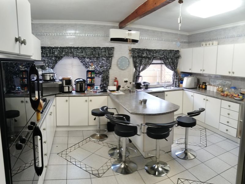 Spacious kitchen featuring a central island, ample built-in cabinetry, tiled flooring, and a split-system air conditioner for climate control.