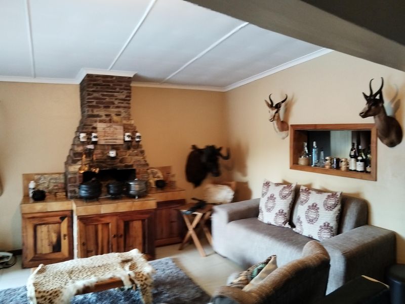 A living room featuring a prominent brick fireplace with built-in wooden cabinetry and a recessed wall niche for storage.