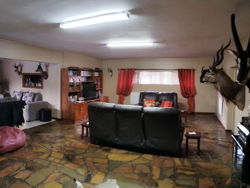 Spacious living area featuring distinctive flagstone flooring and built-in cabinetry, offering a rustic aesthetic with potential for modern updates.
