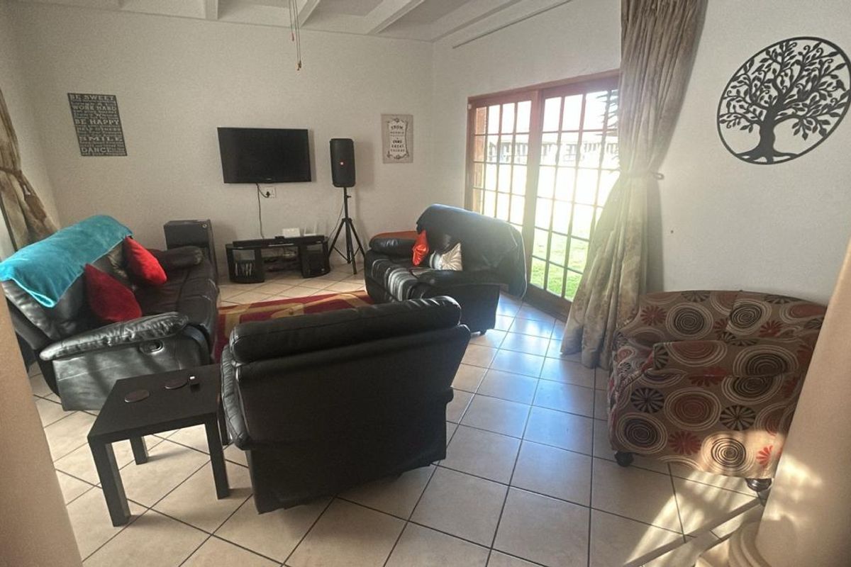 A living room featuring tiled flooring and sliding glass doors that provide direct access to the outdoor area.