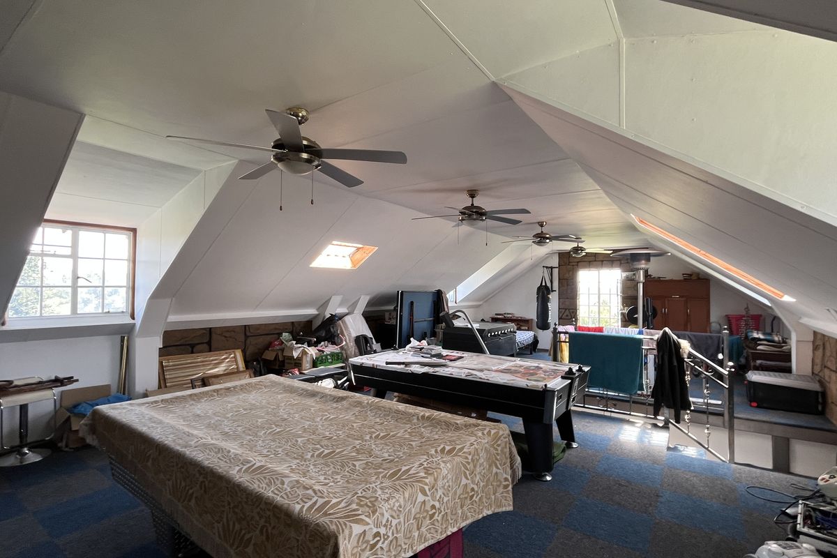 Spacious attic-style living area featuring vaulted ceilings, multiple ceiling fans, skylights, and dormer windows, offering a versatile open-plan layout.
