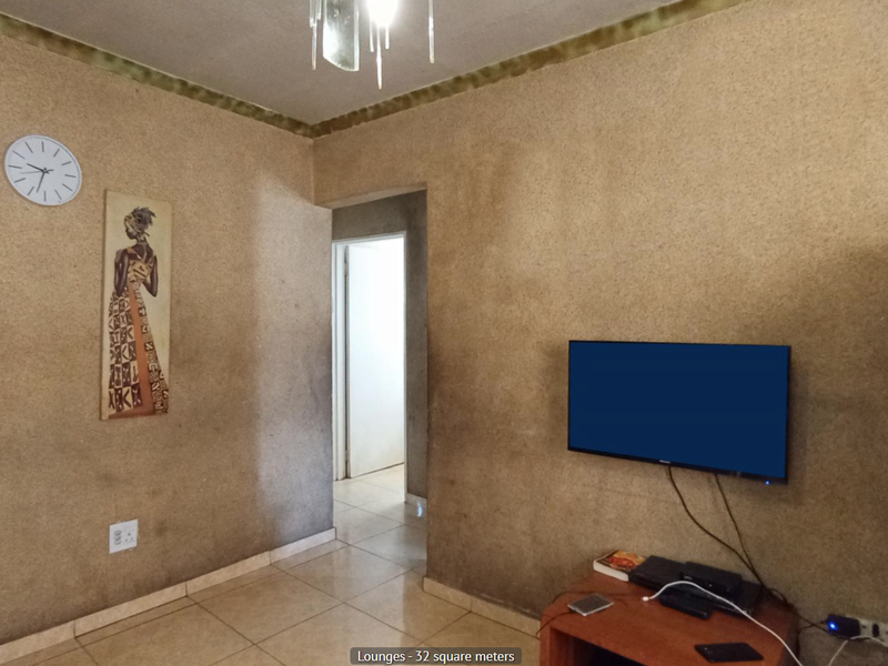 A living room featuring tiled flooring and textured wall finishes with a coved ceiling cornice.