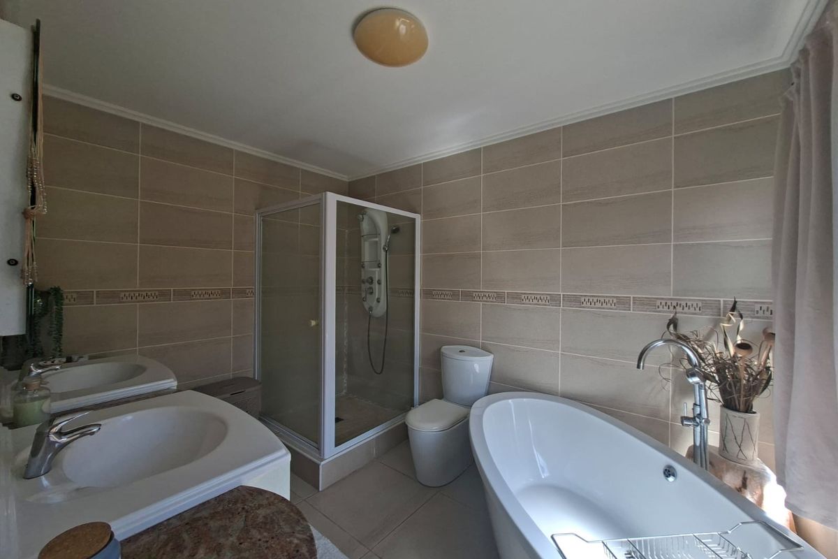 A well-appointed bathroom featuring a freestanding bathtub, a separate glass-enclosed shower, a toilet, and a vanity with a basin.