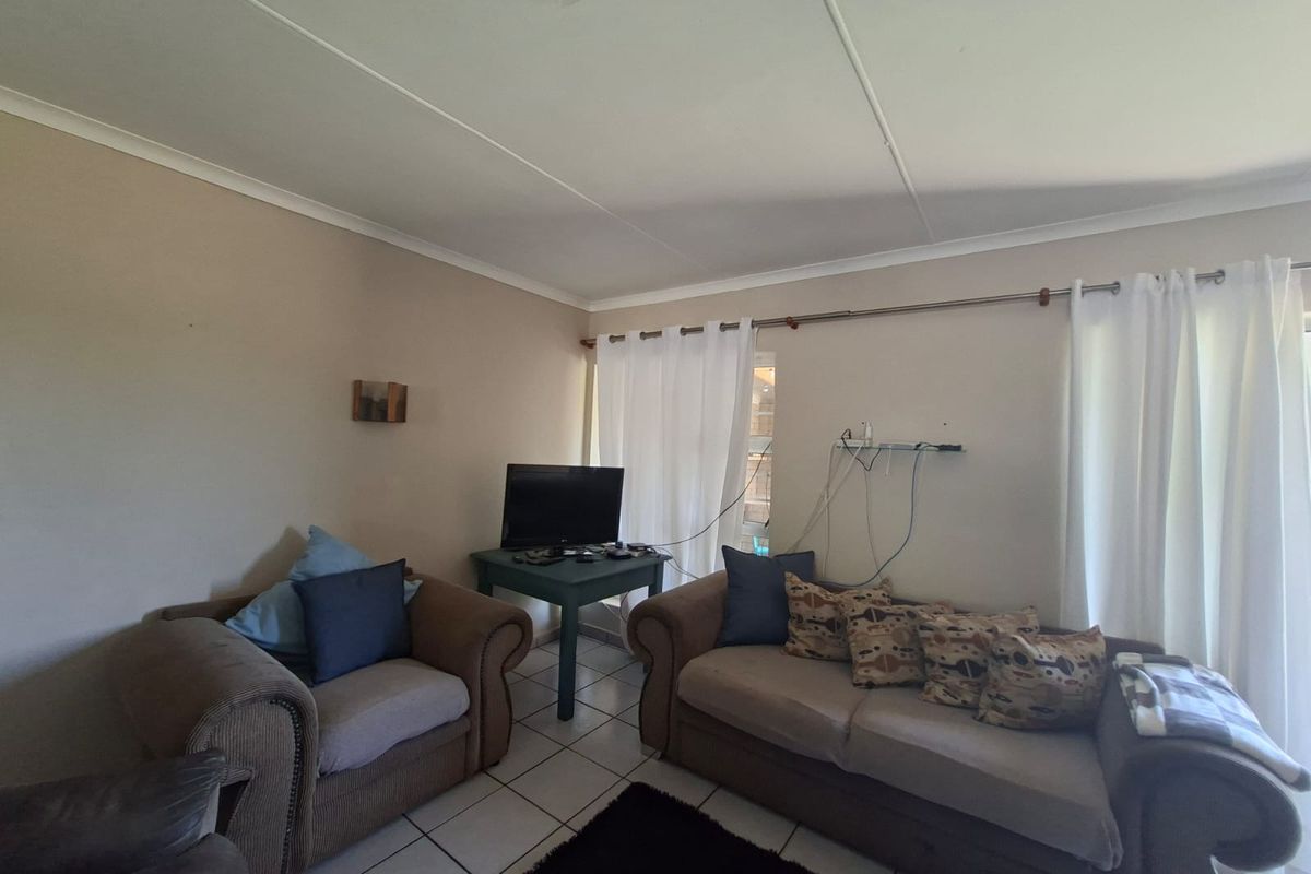 A living room area featuring tiled flooring and neutral wall finishes, providing a functional space for relaxation.