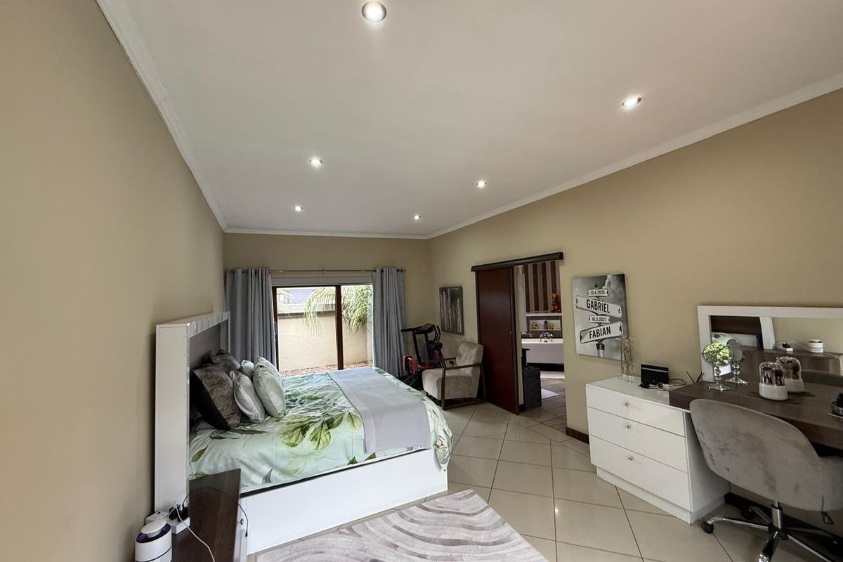 Spacious bedroom featuring tiled flooring, recessed downlighting, and a sliding door providing access to an outdoor area.