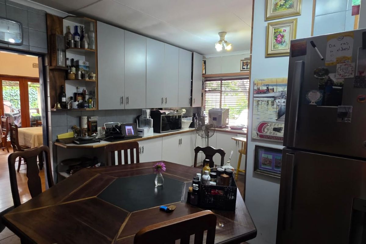 A functional kitchen featuring built-in cabinetry and a breakfast area, with an open transition to an adjacent dining space.