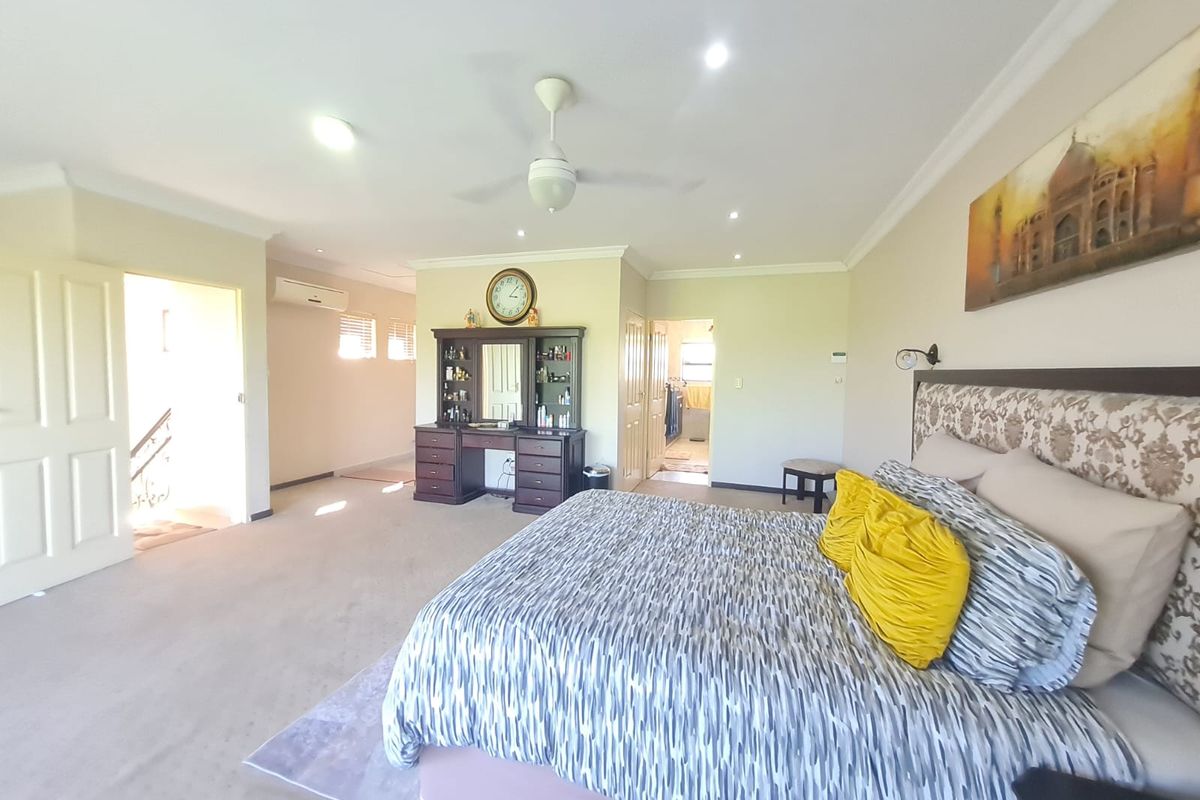 Spacious master bedroom featuring neutral carpeting, recessed downlighting, a ceiling fan, and an integrated air conditioning unit.