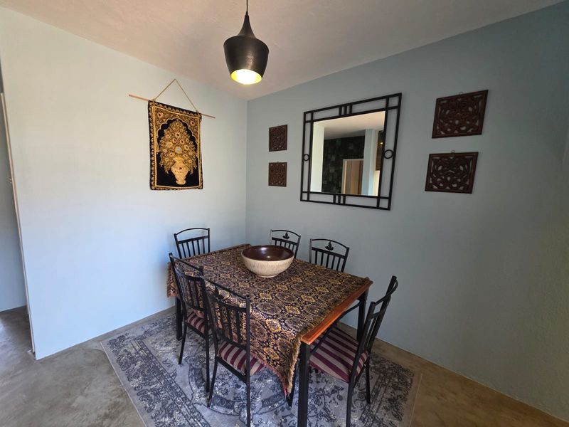 A dining room area featuring a central pendant light fixture and painted walls.