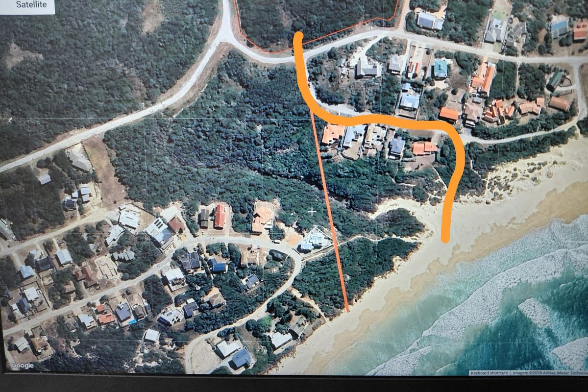 An aerial satellite view showing the coastal residential area, surrounding vegetation, and proximity to the beach.