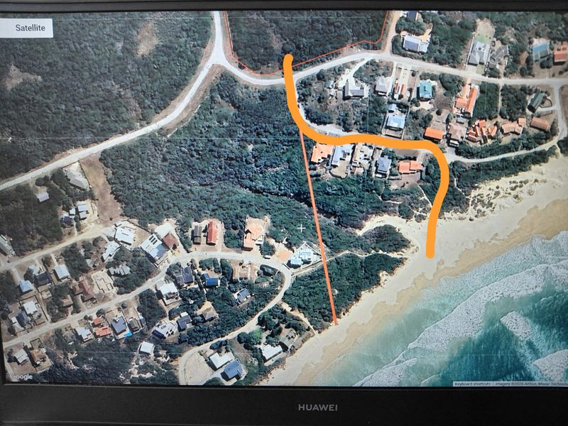 An aerial satellite view showing the coastal residential area, surrounding vegetation, and proximity to the beach.