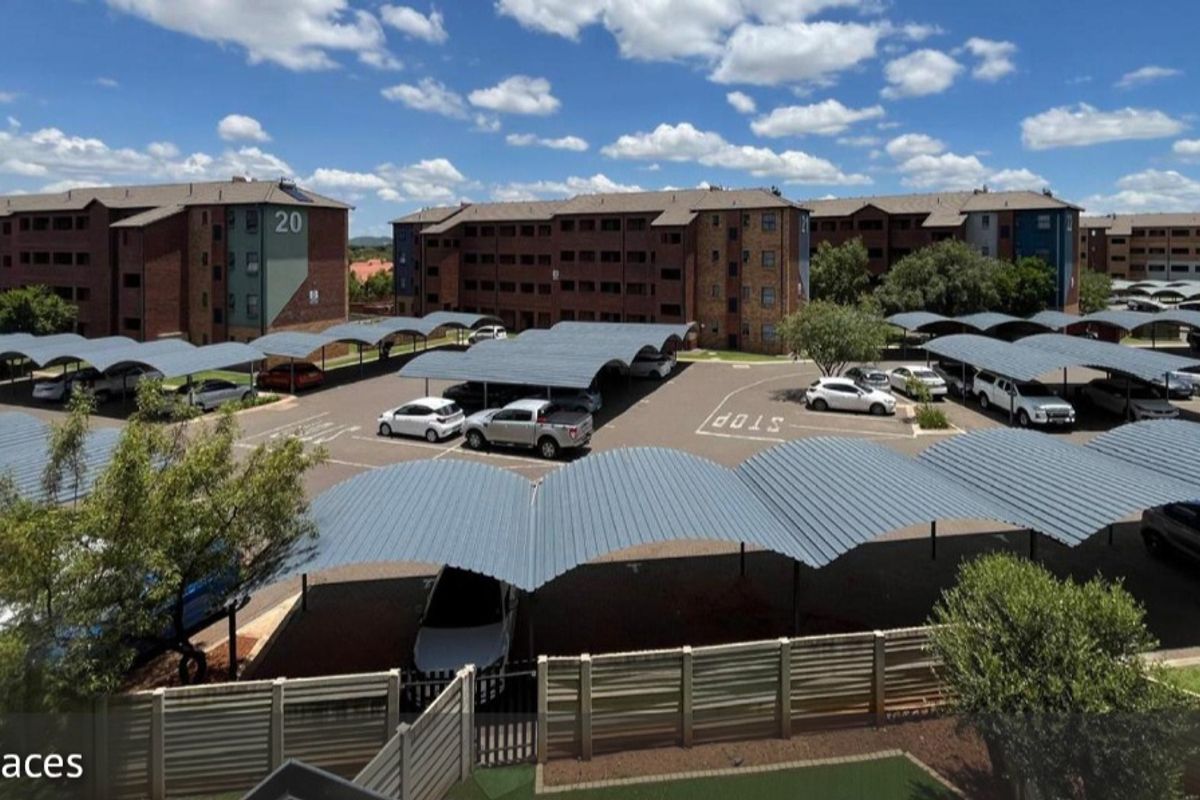 Aerial view of the apartment complex grounds featuring multiple covered parking bays and brick building facades.